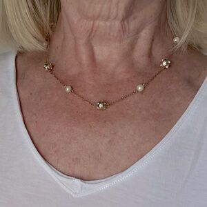 Gold toned necklace with pearls and gold balls containing diamond like stones